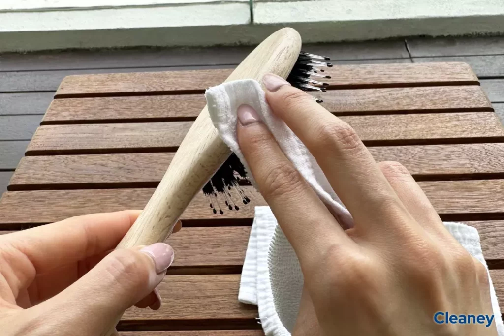 cleaning the side of the wooden hairbrush