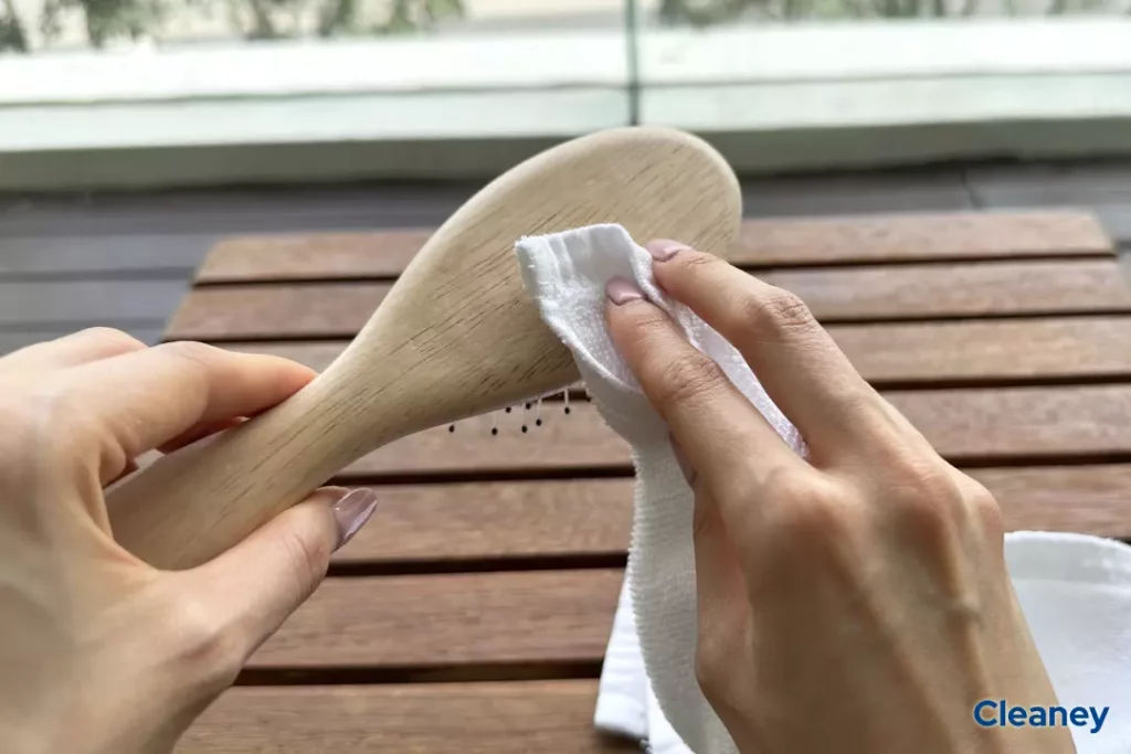 cleaning the base of the wooden hairbrush